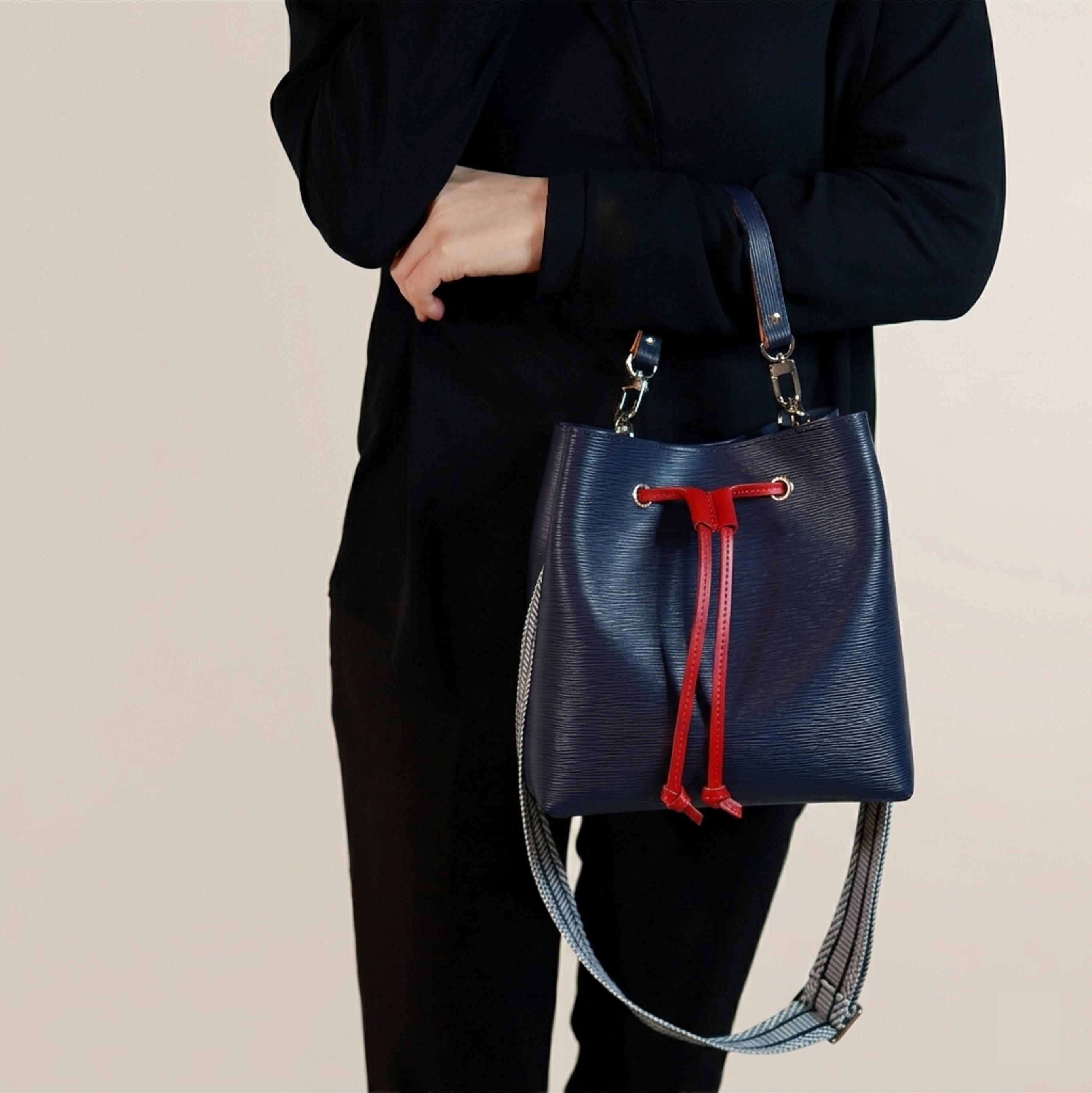Navy Dorothy Bag held by its detachable leather top handle