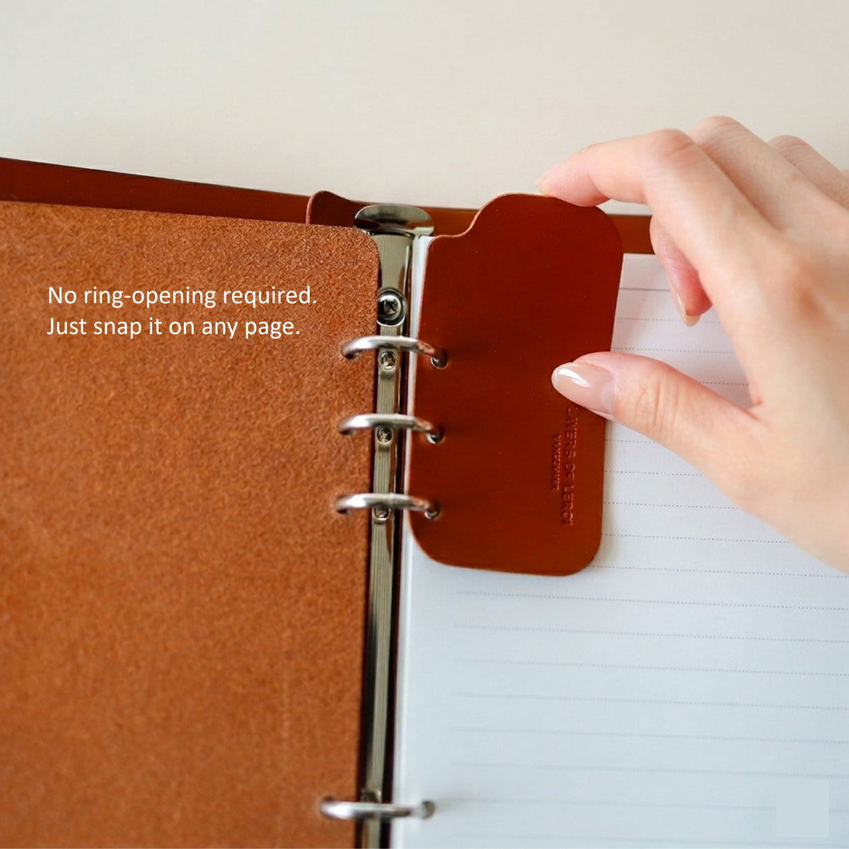 Signature Breve leather bookmark snapping onto A7 ring paper without opening the binder rings
