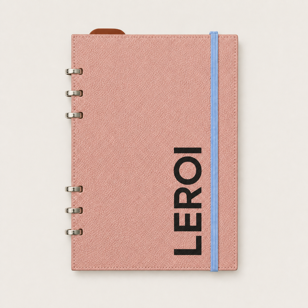 Blush pink leather Smart Ring binder with black vertical LEROI lettering and a blue elastic band