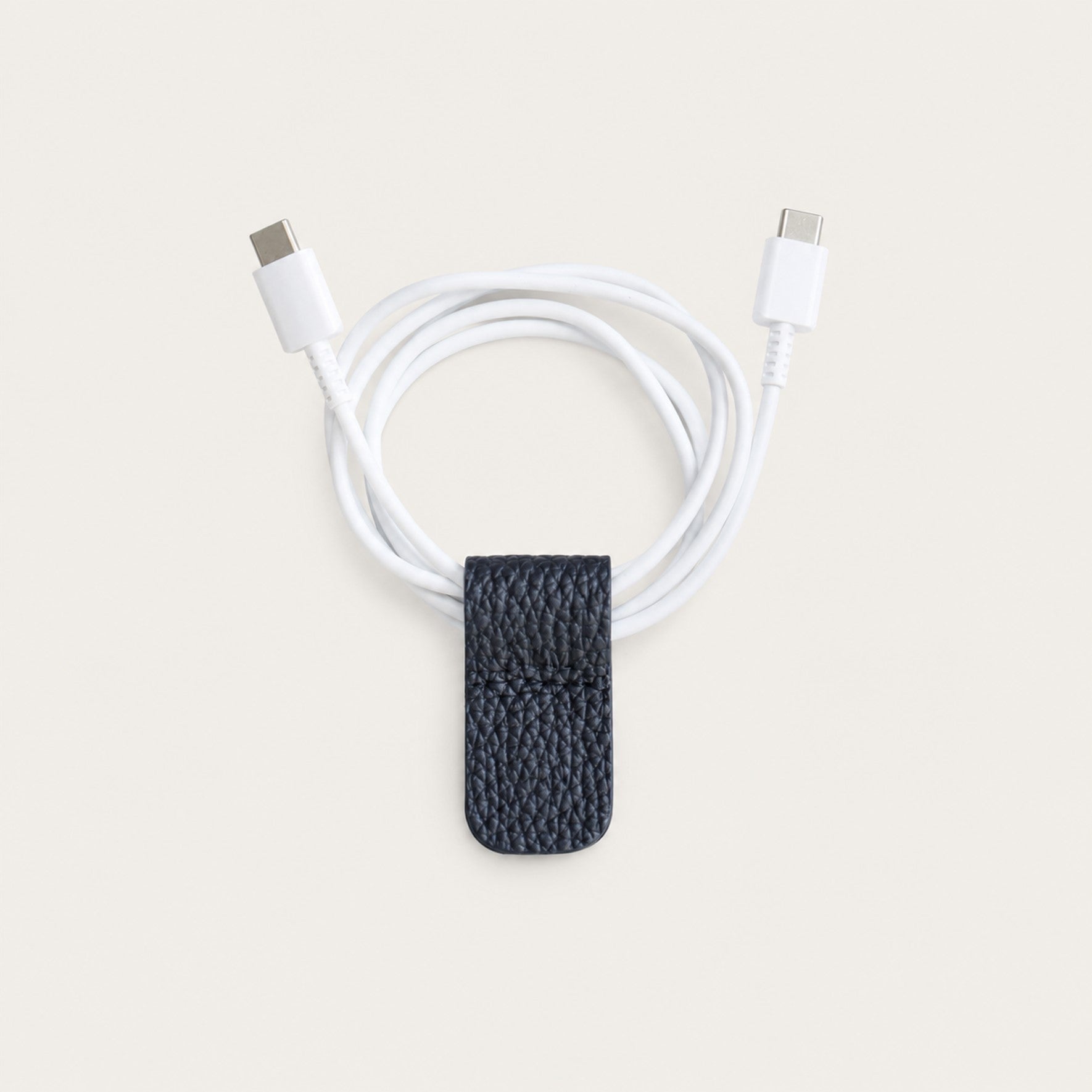 Charging cable secured with a Dark Navy German Togo leather Cord Wrap.