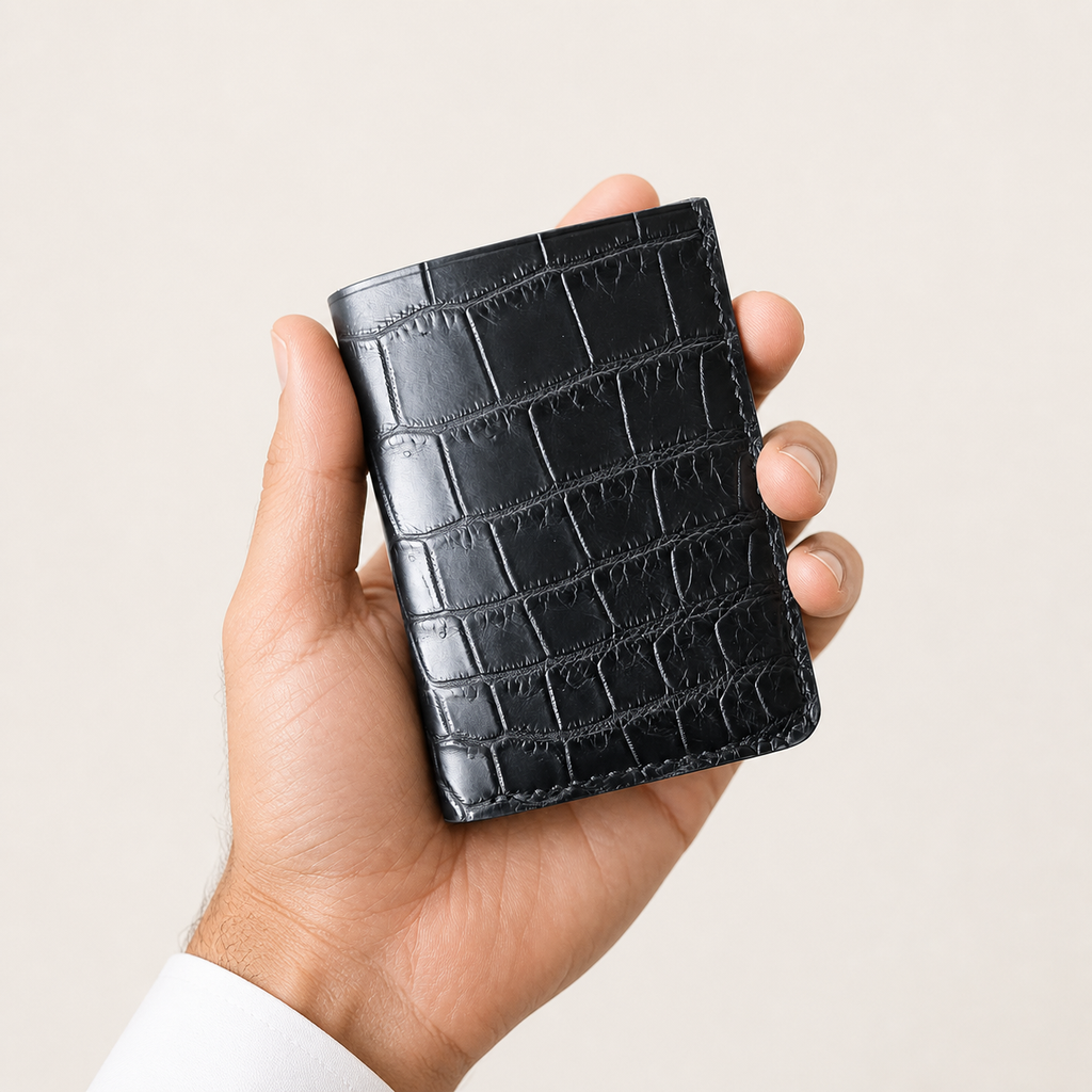 Hand holding a black genuine crocodile leather Tyrian Minimal Wallet