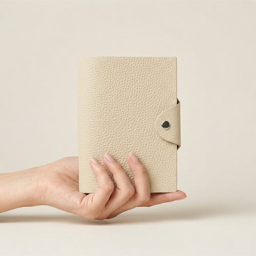 Egg Shell German Togo leather A7 six-ring journal cover held in hand for scale