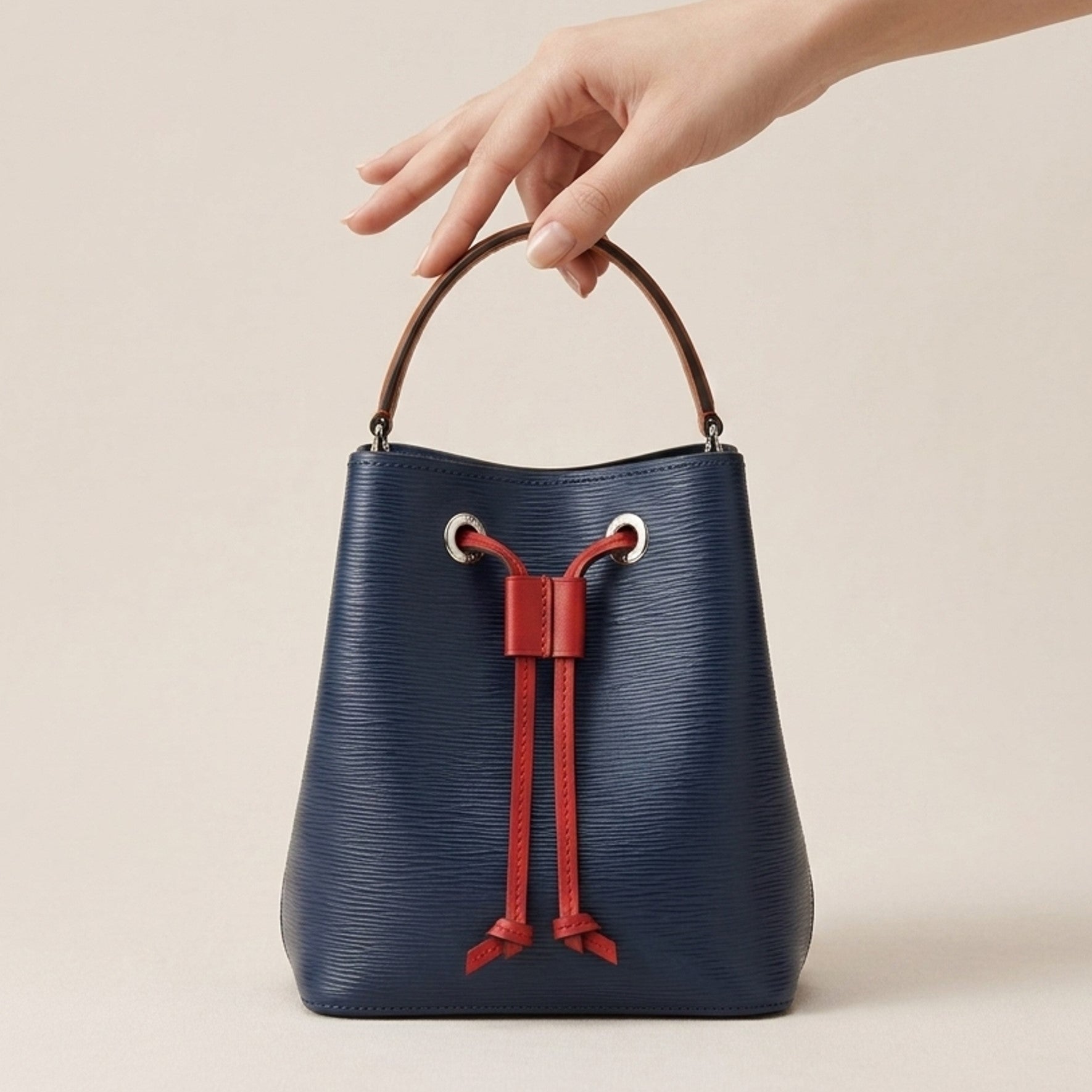 Dorothy Mini Bag held by its detachable leather top handle to show scale