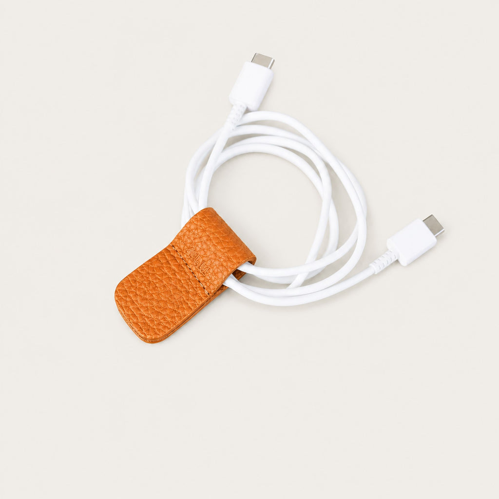 Charging cable secured with an Orange German Togo leather Cord Wrap.