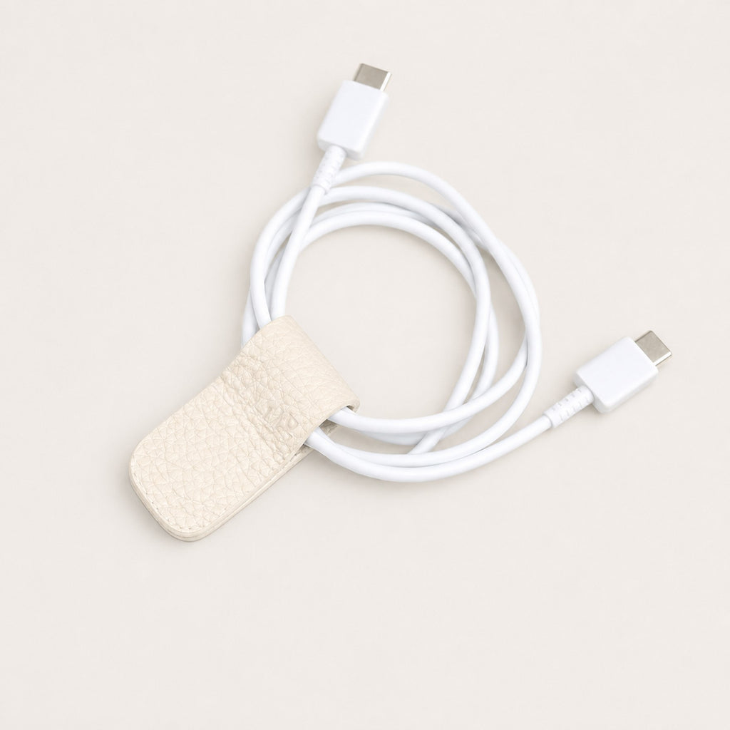 Charging cable secured with an Eggshell German Togo leather Cord Wrap.