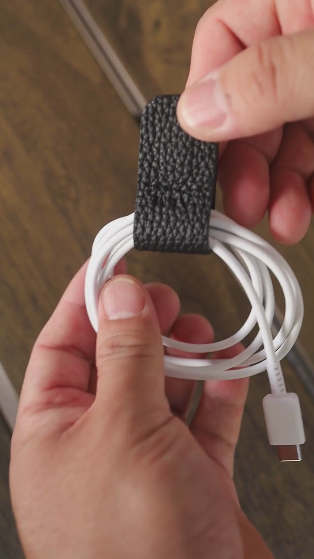 Video showing how to secure a charging cable with the German Togo leather Cord Wrap.